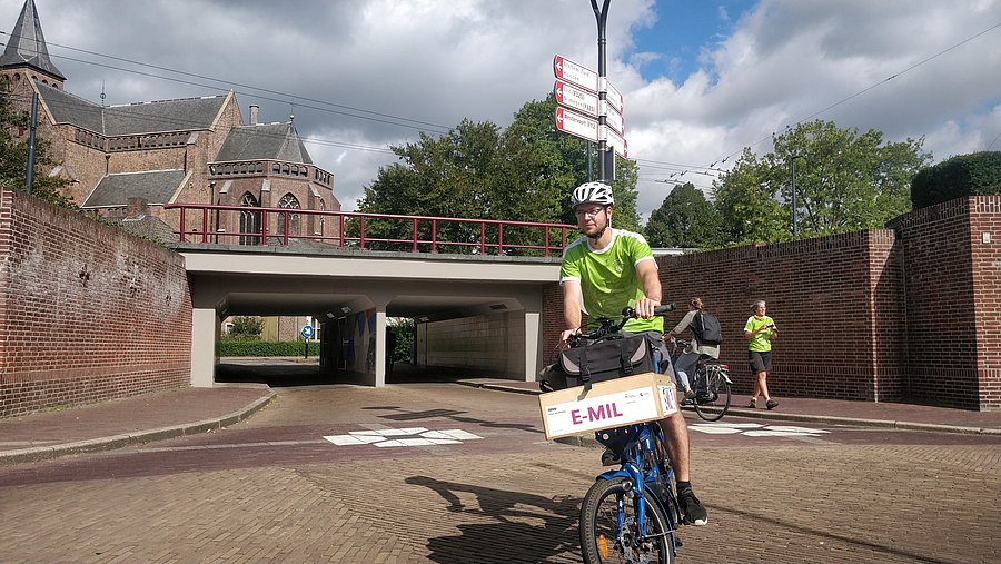 Ein Lastenradfahrer fährt mit dem Lastenrad E-MIL auf einem Radschnellweg in Arnhem.